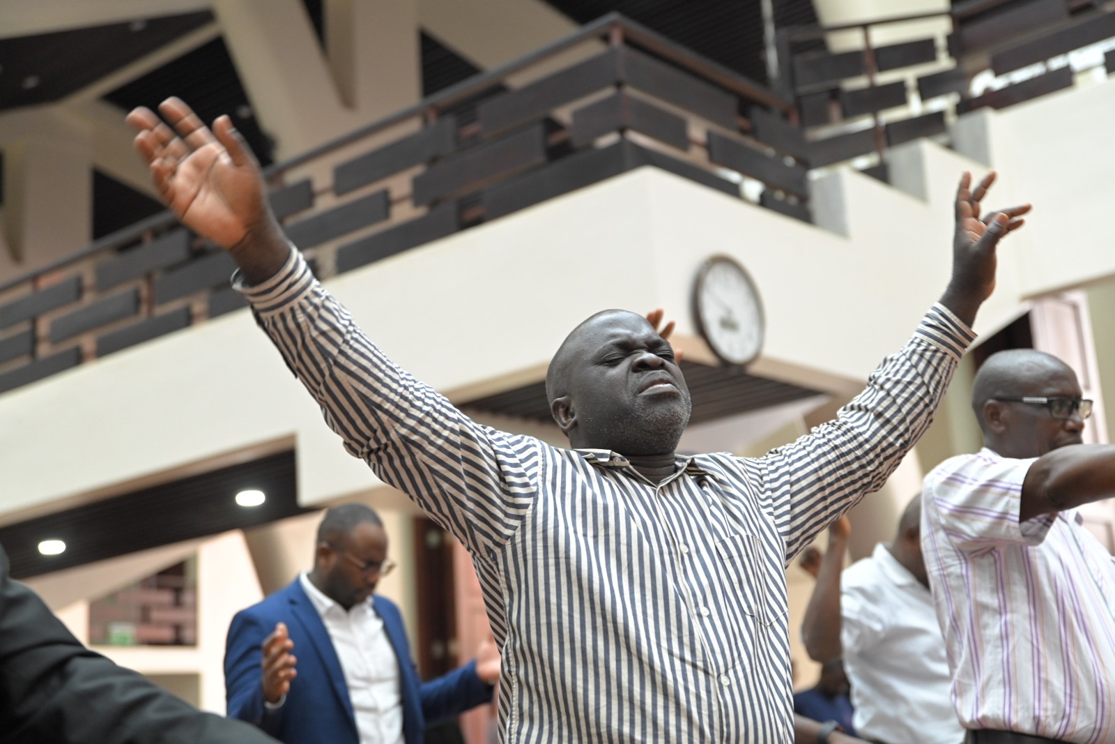 A conference worshipper with his hands raised